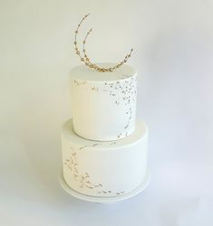 a three tiered white cake with gold sprinkles