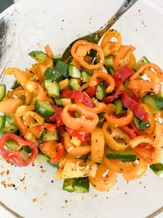 a white plate topped with lots of veggies next to a knife and fork