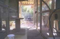 the inside of a caged in area with a bird feeder and water bowl on the floor