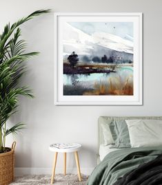 a painting hanging on the wall above a bed in a room with a potted plant