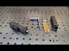 some metal parts are sitting on a table with holes and screws around them,