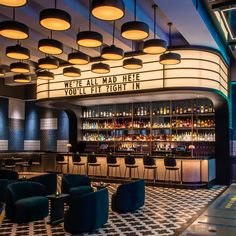 the inside of a bar with chairs and lights