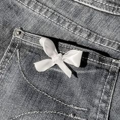 a white bow is sticking out of the back pocket of a pair of jean pants