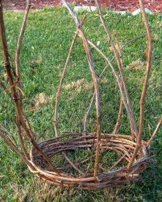 the branches have been arranged into a basket for this planter to hold flowers and other things