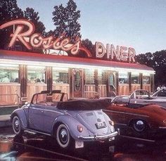 an old photo of cars parked in front of a diner