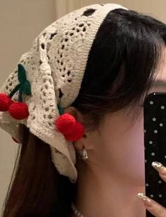 a woman taking a selfie with her cell phone wearing a crochet hat