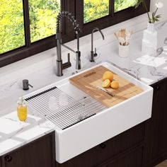 a kitchen sink with two lemons and a cutting board on the counter next to it