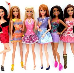 five barbie dolls lined up in dresses and high heeled shoes, all wearing different outfits