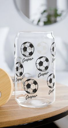 a glass block with soccer balls on it sitting on a table next to a paddle