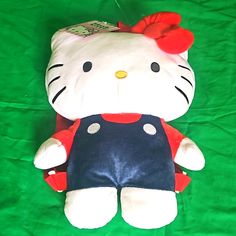 a hello kitty stuffed animal laying on top of a green sheet