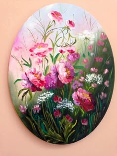 a painting of pink and white flowers painted on a round wall hanging in a room