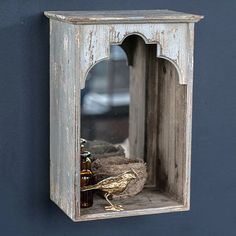 a bird sitting on top of a wooden shelf