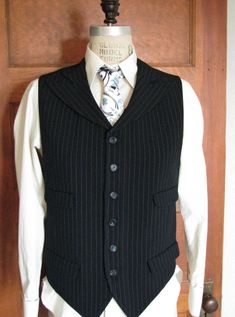 This is our latest vest style. Four pockets and wide peak lapels made for a unique look. This vest is vegan safe, cut from a stunning rayon/poly pinstripe fabric and lined in cotton with skull motifs. But you can choose from hundreds of fabrics including fine wools and silks. We can really make just about any type and style of vest that you can imagine. The matching tie and dress shirt shown in the pics are not included with this price, but we can make those also. Just contact us so we can get s Fitted Black Classic Sweater Vest, Classic Fitted Black Sweater Vest, Black Fitted Classic Sweater Vest, Tailored Pinstripe Sleeveless Vest, Pinstripe Tailored Sleeveless Vest, Tailored Sleeveless Pinstripe Vest, Fitted Pinstripe Vest For Work, Classic Fitted Pinstripe Vest, Fitted Pinstripe Classic Vest