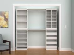 an empty room with a chair and some white shelving units on the wall next to it