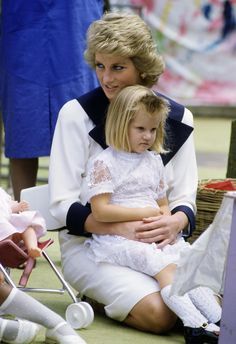 the princess and her daughter are sitting next to each other on the ground with their arms around one another