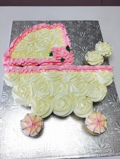 a baby carriage cake with cupcakes on the side