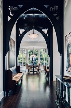 an archway leads to the dining room and formal living area in this house with wood flooring