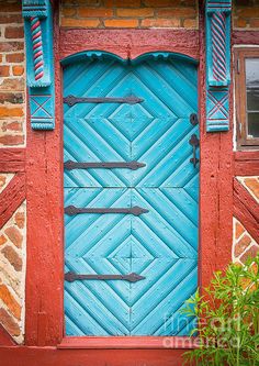 a blue door with red trim on a brick building