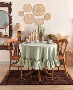 a dining room with a table and chairs covered in a light green ruffled cloth