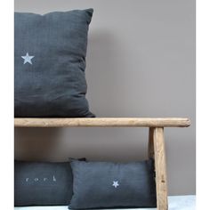 two pillows sitting on top of a wooden bench