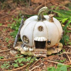 a white pumpkin shaped house sitting on top of a forest floor