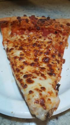 a slice of pizza sitting on top of a white plate