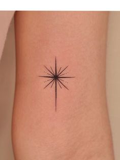 a small star tattoo on the side of a woman's leg, with dots in it