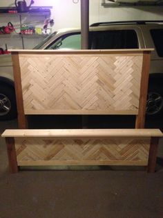 a bench made out of plywood and wood in a garage next to a car