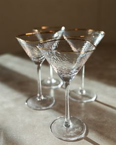 three martini glasses sitting on top of a table