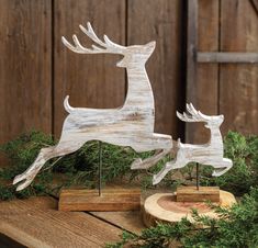 two wooden deer figurines sitting on top of a table