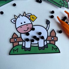 a cow is standing in the grass near some scissors