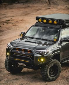 a gray toyota truck with yellow lights on it's headlight and roof rack