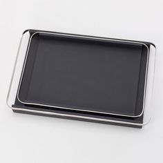 a black tray with silver edges on a white surface, set against a plain background