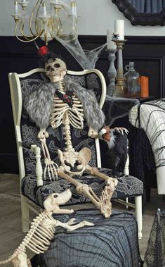 a skeleton sitting on a chair in a living room