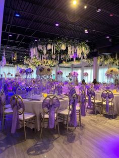 the tables are set up with purple and white decor for an elegant wedding or special event