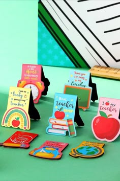 there are many small cards on the table with an apple and books in front of them