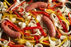 sausages and peppers are being cooked in a skillet with onions, peppers, and mushrooms