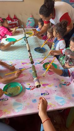 a group of children sitting around a table painting