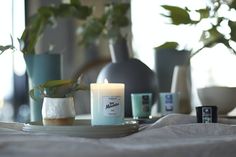 a table topped with candles and vases filled with plants