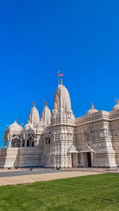 an ornate white building with flags on top