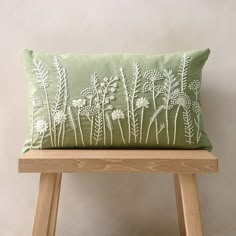 a green pillow sitting on top of a wooden bench