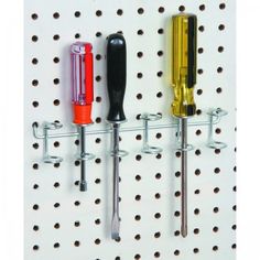 three different colored kitchen utensils hanging on a peg board