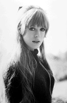 a black and white photo of a woman with long blonde hair wearing a bow tie