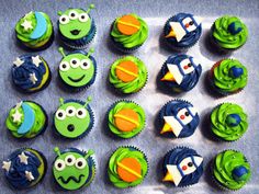 cupcakes with green frosting and blue icing decorated like cartoon character faces