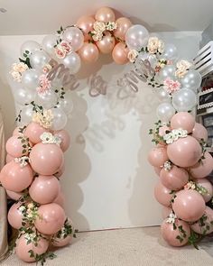 a balloon arch with flowers and balloons attached to it