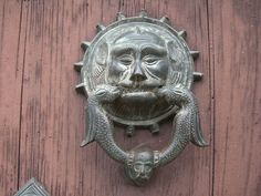 a metal door handle with a face on it's side and two other knobs