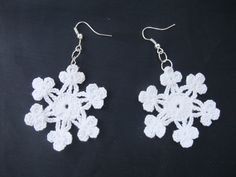 white crocheted snowflake earrings on black background