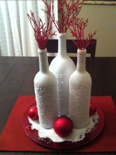 three wine bottles with snow on them are sitting on a red place mat in front of a window