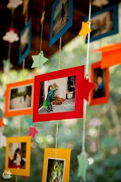 some pictures hanging from a string with star decorations on it and stars attached to the strings