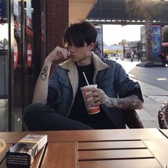 a man sitting at a table with a drink in his hand